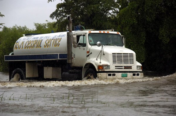 Ricardo Makyn/Staff Photographer.
This Truck Driver takes the  risk to drive in the deep Waters on the Mandela Highway in St Andrew on Thursday 30.9.2010.