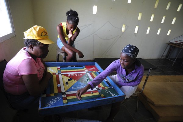 Ricardo Makyn/Staff Photographer 
Residents play a gameof Ludo in the Community Centre in  Manchioneal Portland that is being used as a Shelter for over 30 person's that were displaced due to  the passage of Hurricane Sandy