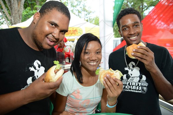 Rudolph Brown/Photographer
From left Sean Anderson, Samantha Josephs and Nicholas Graham get a taste of Reggae Jammin burger at All Jamaica Grill Off at Hope Gardens on Sunday, June 9, 2013