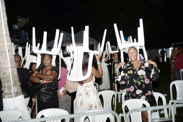 Jermaine BarnabyPhotographerRain did not stop the party, as plastic chairs were used as makeshift umbrellas. *** Local Caption *** Jermaine BarnabyPhotographerRain did not stop the party, as plastic chairs were used as makeshift umbrellas.
