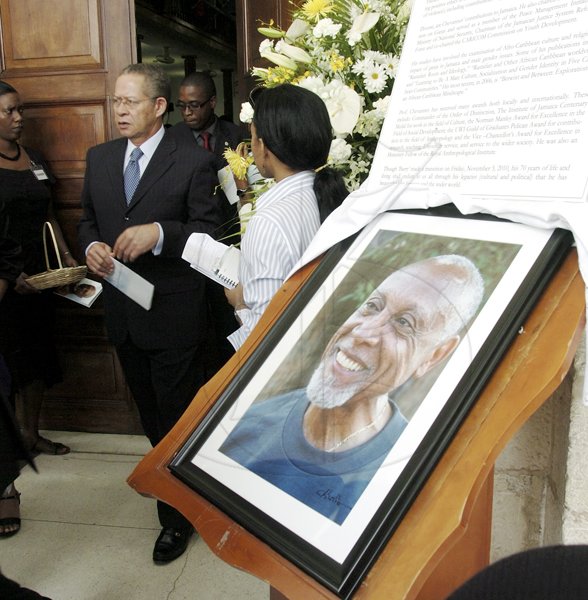 Ricardo Makyn/Staff Photographer
Prime Minister Bruce Golding walks by a portrait of the late Professor Barry Chevannes at the funeral held for the educator at the University of the West Indies Chapel in St Andrew yesterday. See story on A3