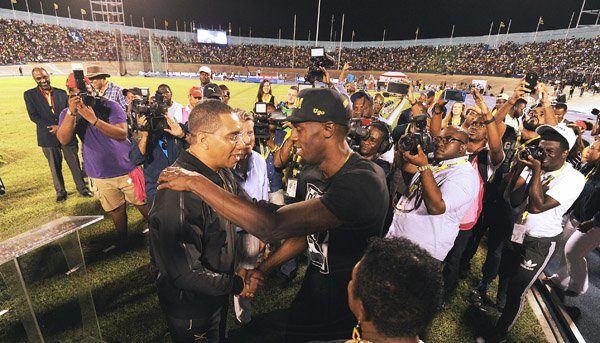 x *** Local Caption *** Ricardo Makyn/PhotographerJamaica's sprint legend Usain Bolt is greeted by Prime Minister Andrew Holness before a massive crowd at the JN Racers Grand Prix inside the National Stadium last night.