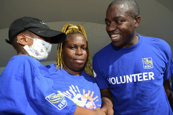 Rudolph Brown/Photographer
Roger Cogle, Market Head, Personal Banking at RBC Royal Bank (Jamaica) speaks with Tafari Forte and his mother Sophia Lewis, at the RBC Royal Bank Caribbean Children's Cancer Fund, " A Mile for a Child" join with family and friends participate in a charity walk and a fun class of Zumba and aerobics session at the Emancipation Park in New Kingston on Saturday, September 8-2012