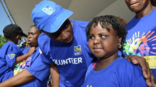 Rudolph Brown/Photographer
Roger Cogle, Market Head, Personal Banking at RBC Royal Bank (Jamaica) speaks with Ashanti Knight, (right) while Tafari Forte and his mother Sophia Lewis, (left) looks on, some of the cancer survivors children at the RBC Royal Bank Caribbean Children's Cancer Fund, " A Mile for a Child" join with family and friends participate in a charity walk and a fun class of Zumba and aerobics session at the Emancipation Park in New Kingston on Saturday, September 8-2012