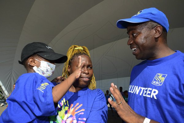 Rudolph Brown/Photographer
Roger Cogle, Market Head, Personal Banking at RBC Royal Bank (Jamaica) speaks with Tafari Forte and his mother Sophia Lewis, at the RBC Royal Bank Caribbean Children's Cancer Fund, " A Mile for a Child" join with family and friends participate in a charity walk and a fun class of Zumba and aerobics session at the Emancipation Park in New Kingston on Saturday, September 8-2012