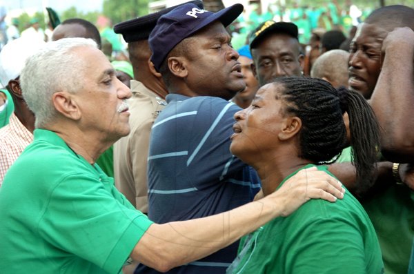 Rudolph Brown/Chief Photographer
Minister of National Security Colonel Trevor MacMillan speaks with a distraught Jamaica Labour Party supporter after a shooting which resulted in the death of at least one person during the party's 65th annual conference at the National Arena yesterday.