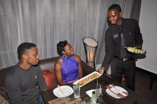 Jermaine Barnaby/Photographer
Restaurant Week Ambassador Juilet Flynn and husband Levaughn being served by a waiter at Majestic Sushi and Grill, Valla Ronai, Old Stony Hill on Wednesday, October 30, 2013.