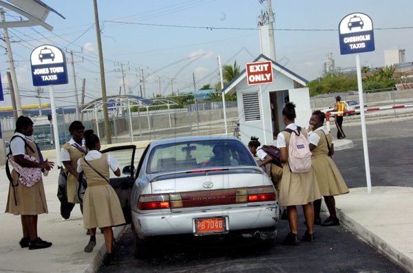 Norman Grindley/Chief Photographer
Schoolchildren board a route taxi at the Water Lane terminal of the new Downtown Kingston Transport Centre yesterday. Confusion reigned at the transport hub yesterday as many commuters did not know where to board buses and taxis.

Operations at the centre was officially open last Saturday.