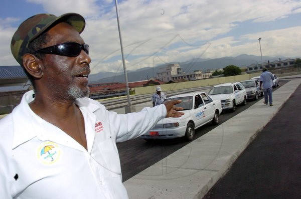 Norman Grindley/Chief Photographer
Raymond Bynes, president of the All-Island Route Taxi Association, explains some of the difficulties being faced  by his organisation's members at the Water Lane terminal of the new downtown Kingston transport centre yesterday.