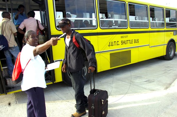 Norman Grindley/Chief Photographer
Beverly Holness (left), of the Jamaica Urban Transit Company, explains the shuttle bus service at the new downtown transport centre yesterday. The centre was officially opened last Saturday.
