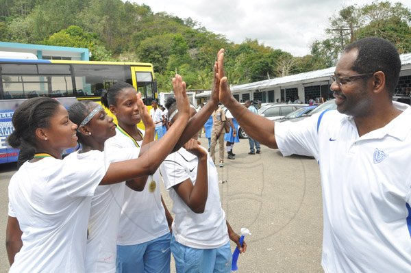 Jermaine Barnaby/Photographer
Dr. Everton Walters (right) principal of Edwin Allen gives high fives to the winning 4 x 100m relay team members from left; Lisandra Brown, Shanique Rowe, Kevona Davis and Selisa Palmer during the schools' Champs win celebration at the school on Monday March 30, 2015.