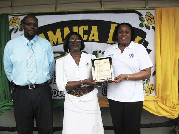 Contributed 
Mr. Paul Grant- Principal looking on as Mrs. Marilyn Mason-Anderson- Vice Principal and Mrs. Sylyn Brown- Hamilton, 
Purchasing Officer, share a picture with the Children’s Own plaque at May Day High School
