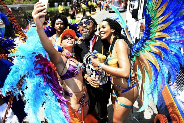 Gladstone Taylor<\n>Selfie time! Simone Mahfouz (left) and Kerah Bryant, snap a selfie with Trinidadian soca sensation Machel Montana during Xodus Carnival road march yesterday.