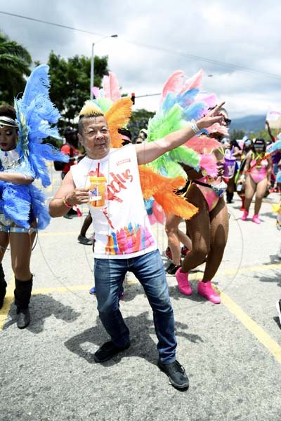 Gladstone Taylor<\n>Brian 'Ribbie' Chung  shares the lightining bolt pose with our lens as he joined the revellers in yesterday's road march.