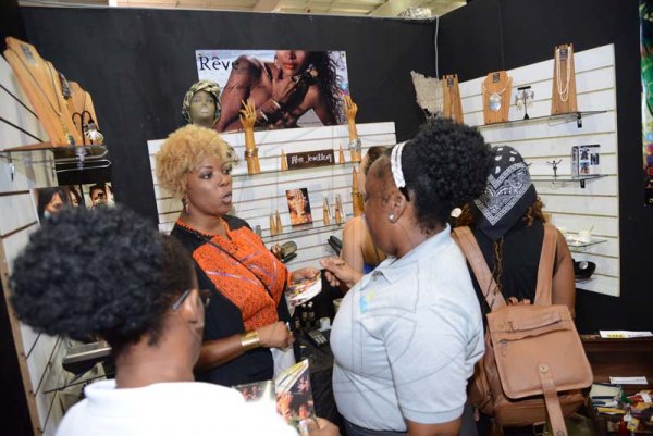 Rudolph Brown/ PhotographerTesea Bennett (second left) of Reve Jewellery show her product at the JEA JMA Expo Jamaica at the National Indoor Sports Centre and the National Arena on Sunday April 22, 2018