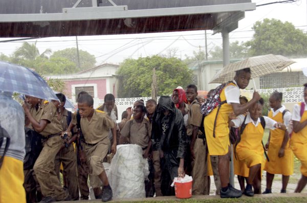 Norman Grindley/Chief Photographer
Students of Donald Quarrie High School shelter from the heavy rains that flooded sections of Harbour View, St Andrew yesterday.