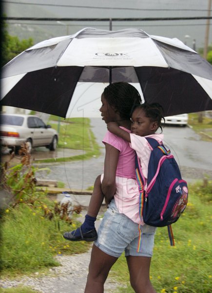Norman Grindley/Chief Photographer
This woman piggy back a little girl from school in Harbour view in East Kingston during the heavy rain yesterday.