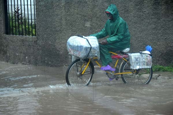 Ian Allen/Photographer
A newspaper vendor rides his bicycle through flood waters along Spanish Town road during heavy rains on wednesday. Ian Allen/Photographer
Motorist making their way through flood waters along Spanish Town Road during heavy rains on wednesday.