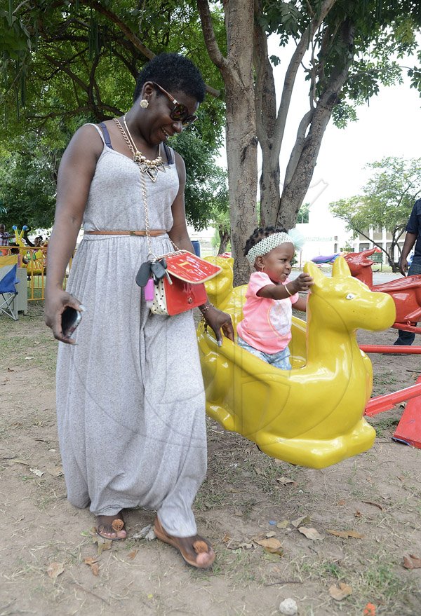 Ian Allen/Photographer
Ann Marie Dougl;as walk beside her daughter Tarjai Green  as she enjoys a ride while they attended the Lasco Family Extravaganza at Hope Gardens on Boxing Day 2015.