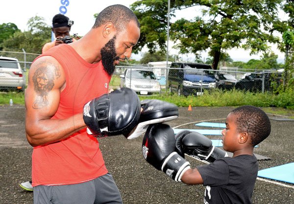 Lionel Rookwood/PhotographerThe Gleaner's Fit 4 Life event with the Trainfit Club's Outdoor Madness, Boxing Fitness with Sakima Mullings and Self Defense with Master Arthur Barrows on Saturday, November 11, at In Motion Gym, Shortwood Teachers' College, St Andrew. *** Local Caption *** Lionel Rookwood/PhotographerContender champion Sakima Mullings giving this youngster boxing lessons.