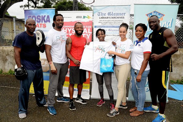 Lionel Rookwood/PhotographerThe Gleaner's Fit 4 Life event with the Trainfit Club's Outdoor Madness, Boxing Fitness with Sakima Mullings and Self Defense with Master Arthur Barrows on Saturday, November 11, at In Motion Gym, Shortwood Teachers' College, St Andrew. *** Local Caption *** Lionel Rookwood/PhotographerWinner of the boxing challenge, Faith Browne (centre), is all smiles with her FLOW phone and The Gleaner's Fit 4 Life T-shirt. Also pictured are: boxing champion Sakima Mullings (third left); Sherida Cohen (second right), brand manager of Chas E. Ramson; Amashika Lorne (third right), Gleaner's marketing officer and Marvin Gordon (second left), The Gleaner's Fit 4 Life fitness coach. Members of Sakima's boxing team join in for the presentation.