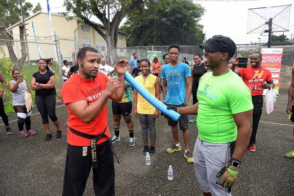 Lionel Rookwood/PhotographerThe Gleaner's Fit 4 Life event with the Trainfit Club's Outdoor Madness, Boxing Fitness with Sakima Mullings and Self Defense with Master Arthur Barrows on Saturday, November 11, at In Motion Gym, Shortwood Teachers' College, St Andrew. *** Local Caption *** Lionel Rookwood/PhotographerMaster Arthur Barrows, president of the Jamaica Taekwon-Do Association, taking The Gleaner's Fit 4 Life participants through a series of self defense lessons.