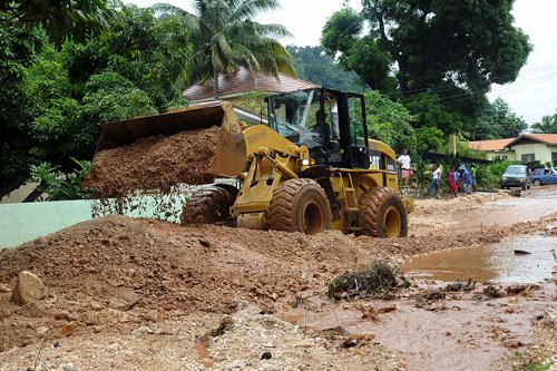 Ian Allen/Photographer
A Backhoe clears silt and debris from sections of Riverside Drive after the rains from Tropical Storm Nicole .