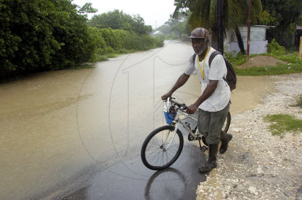 Ricardo Makyn/Staff Photographer.
A cyclist attempts to enter a flooded road in Spanish Town.







walks by the Flooded Road in Spanish Town on Wednesday 29.9.2010.