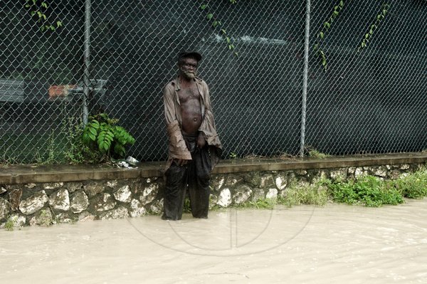 Adrian Frater photo

NO PLACE TO GO: This homeless man was trapped in the water along the Bogue main road in Montego Bay on Wednesday.