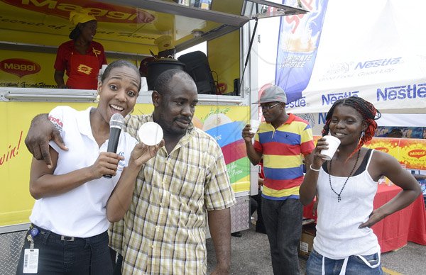 Gladstone Taylor / Photographer

Terry-Karelle Reid acknoledges Omar Wilson (2nd left) as the winner of the maggie soup drinking contest  as seen at the Gleaner company food moth promotion held at shoppers fair super market on brunswick avenue, spanish town on saturday