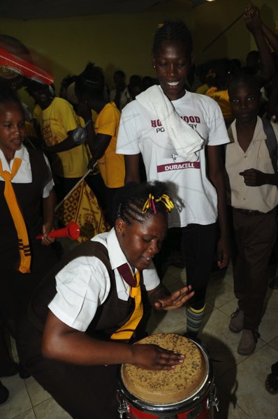 Norman Grindley /Chief Photographer
This student is caught beating a drum during Holmwood's celebration after winning their eight straight title at the ISSA/GraceKennedy Boys' and Girls' Championships inside the school's auditorium yesterday.