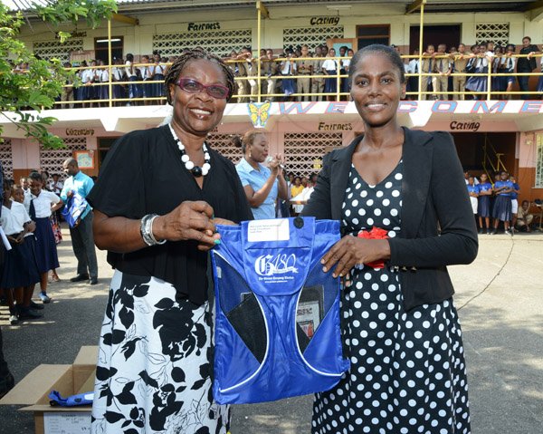 Ian Allen/Photographer
Avis Walker-Gordon left, Vice Principal of The Holy Family Primary School presents a Gleaner 180th anniversary bag to Sandy Muir right on Teachers Day on Wednesday.
