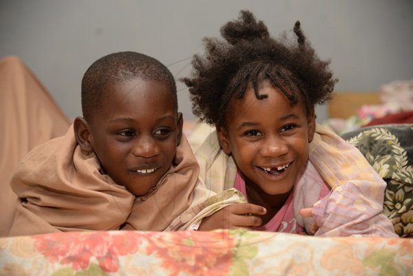 Jermaine Barnaby/Freelance PhotographerDespite being in a shelter, four-year-old Matthew Adeyemi (left) and five-year-old Aviana Taylor had something to smile about at the Manchoniel All Age School in Portland.