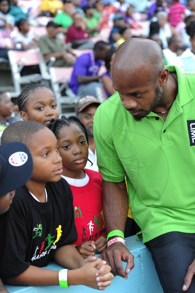 Ricardo Makyn/Staff Photographer
Asafa Powell with Kids   at the Boys and Girls Championships at the National Stadium on Friday 30.3.2012