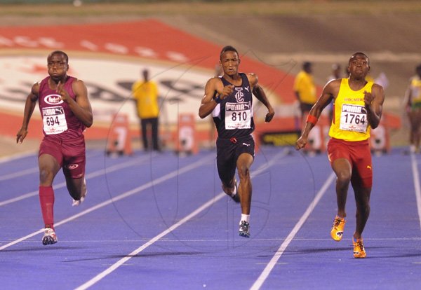 Ricardo Makyn/Staff Photographer
at right Raheeem Robinson of Wolmers powers by at far left Gawain Williams of Herbert Morrison and Tyler Mason of Jamaica College to win the Boys' 100 Meter Class 2 at the Boys and Girls Champs 2012