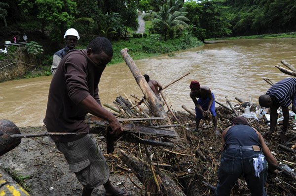 Ricardo Makyn/Staff Photographer
Residents feverishly trying to remove debris from the Flat Bridge in the Bog Walk Gorge in St Catherine on Monday 27.8.2012