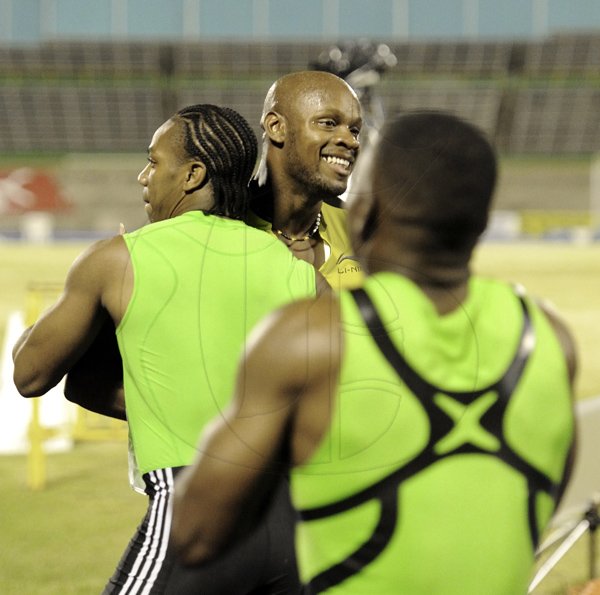 Ricardo Makyn/Staff Photographer
National champion Asafa Powell gets a congratulatory hug from runner-up Yohan Blake, while third-place Steve Mullings looks on, following the men's 100 metres final on Friday night, at the Jamaica Athletics Administrative Association/Supreme Ventres Limited National Senior Championships, at the National Stadium. Powell won in 10.08 seconds, while Blake and Mullings recorded 10.09 and 10.10-second clockings, respectively.