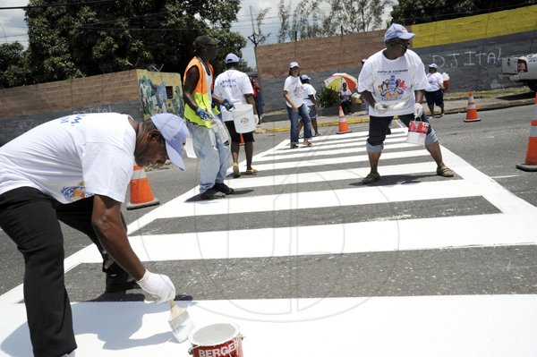 Norman Grindley/Chief Photographer
Staff of Crazy Jim along with technical persons from the National Works Agency (NWA) re paint pedestrian crossing at Cockburn gardens primary school in St. Andrew yesterday.
