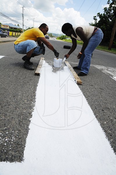 Ricardo Makyn/Staff Photographer
Members of the Little Feet Basic School Parent Teachers Association on Brunswick Avenue in Spanish Town.
Painting the Pedestrian Crossing adjacent to the School as their Labour Day Project on Monday 23.5.2011