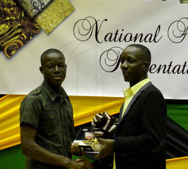 Winston Sill/Freelance Photographer
The Jamaica Cultural Development Commission (JCDC) presents Jamaica Visual Arts Competition Awards and Exhibition, held at the Jamaica Conference Centre, Downtown, Kingston on Sunday December 22, 2013. Here Christopher Miller (right), Director of Tourism Enhancement Fund, presnents Wenroy Messam (left) with his awards in Youth Category.