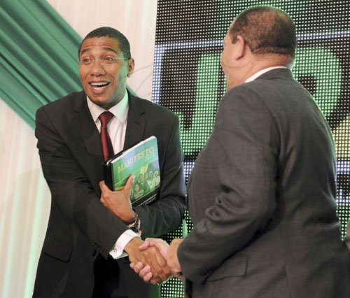Ricardo Makyn/Staff Photographer
Prime Minister Andrew Holness shakes hands with Minister of Finance Audley Shaw during the Jamaica Labour Party's launch of its manifesto at The Jamaica Pegasus hotel in New Kingston yesterday.