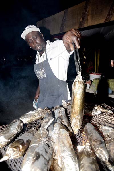 Lionel Rookwood/Photographer<\n>Kevheir Allen shares a roasted fish for the guest.
