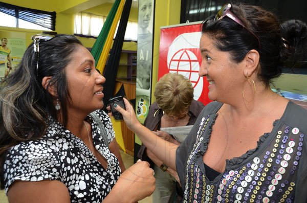 Rudolph Brown/Photographer
Curator of the Gleaner/Scotiabank archival exhibition 'The Journey of Champions: 50 Years of Jamaicam Athletic Excellence', Susanne Fredricks (right) shares a laugh with graphic artiste Heather Kong during the exhibition launch at the St Catherine Parish Library yesterday. 

Launch of The Gleaner/Scotiabank Photo exhibition at St. Catherine Parish Library, Spanish Town on Wednesday, February 1-2012