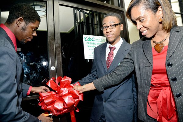 Rudolph Brown/Photographer
Business Desk
Gail Dixon, general Manager and Directors Antoan Hutchinson, (left) and Gibran Hutchinson cutting the ribbon to officially open Kris An Charles Investment Company Limited new office at the launch on 2 Eureka Crescent in Kingston on Thursday, September 5, 2013