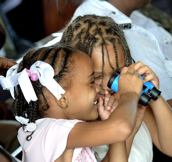 Ian Allen/Staff Photographer
Atonia Barker right  Tetanya Merchant Francis left  plays with a toy binocular during the National Workers' Week and Labour Day Thanksgiving Church Service under the theme:"Take a Stand...Beautify Our Land". The Service was held at the Covenanat Moravian Church in Kingston on Sunday.