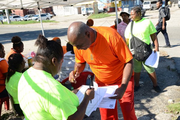 Rudolph Brown/Photographer
Outdoor agent checking the voters list at Pembroke Hall High School on Monday November 28, 2016