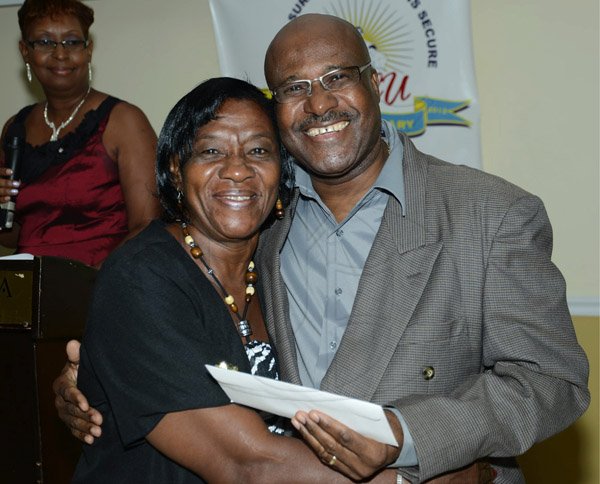 Rudolph Brown/Photographer
BUSINESS DESK
Winston Fletcher, (right) President presents Melva Grier Jones with 35 years award at the credit union's 35th anniversary annual long service awards luncheon  at the Terra Nova Hotel in Kingston on Wednesday, December 5,2012
