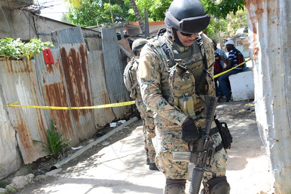Rudolph Brown/PhotographerThe Military patrolling after gunmen shoot up seven killing five including three children and set their home ablaze at Africa settlement in March Pen Community in Spanish Town on Sunday, October 9