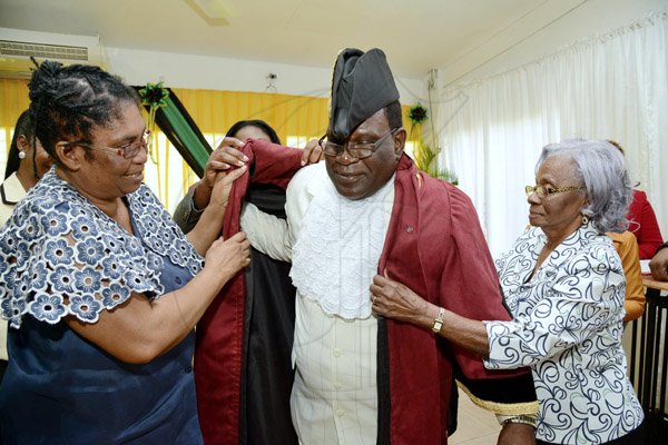 Rudolph Brown/Photographer
His Worship the Mayor Ludlow Mathison been robing by his mother Herma Mathison, (right) and Councillor Joan Spencer Former mayor of Morant Bay at the Investiture ceremony for the conferment of Titles of Mayor and Deputy Mayor of Morant Bay at Casa Lagoona Hotel, Pamphret St. Thomas on Wednesday, May 14, 2014