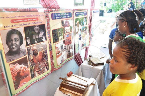 Jermaine Barnaby/Photographer
Students from Hope Valley Experimental school view exhibits of Miss Lou during her 94th Birthday Anniversary Celebrations organised by the Jamaica Cultural Development Commission (JCDC) last  Saturday, September 7, 2013 at the LOUISE BENNETT GARDEN THEATRE, HOPE ROAD, KINGSTON.